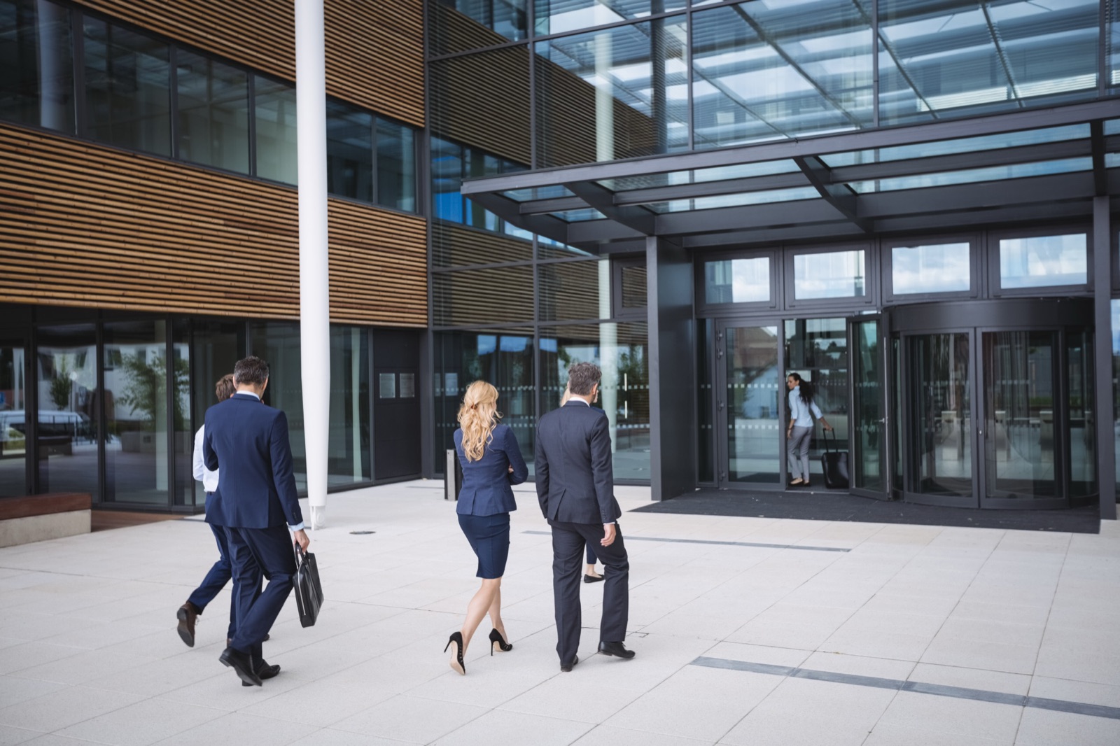 Edificio corporativo con personas llegando al trabajo